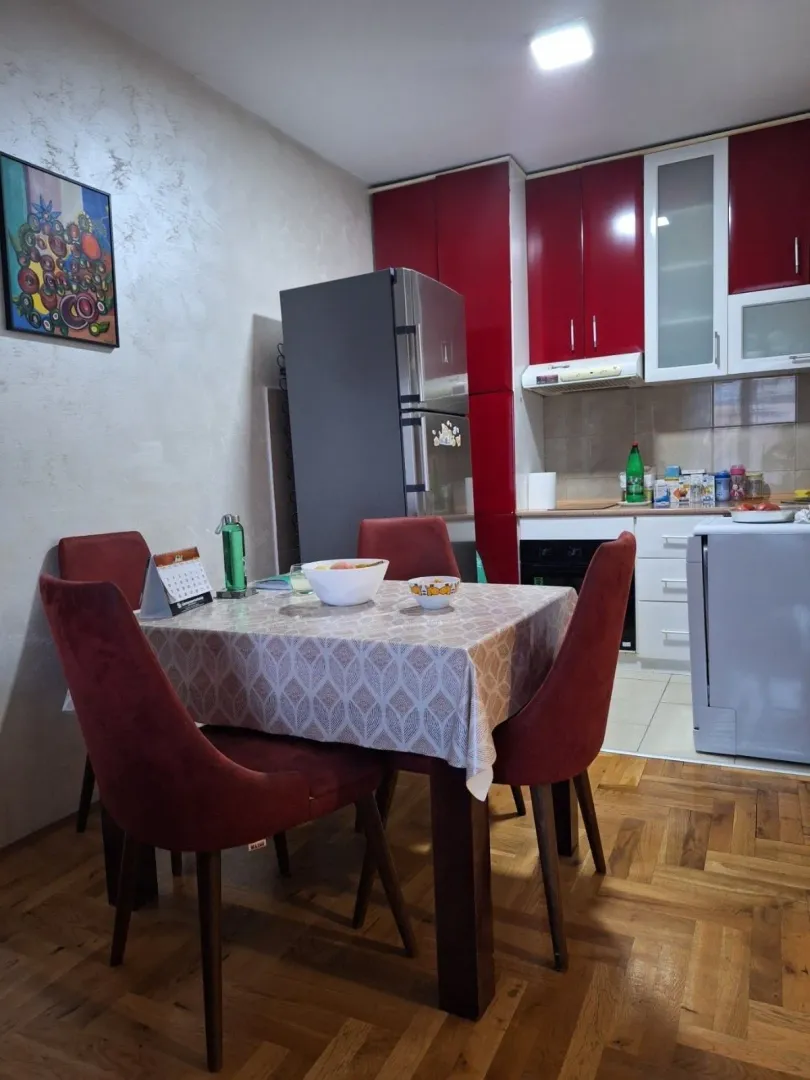 Trpezarija sa trpezarijskim stolom i stolicama, u nastavku kuhinja.