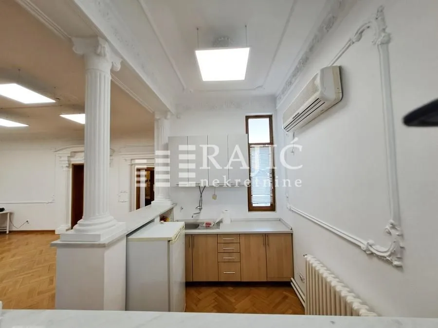 Smaller kitchen with wooden units within a spacious living area.
