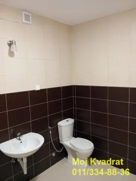 Bathroom equipped with a washbasin and toilet, tiled in two colors. - image 7