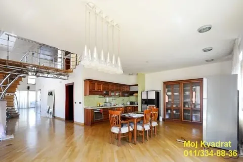 Spacious kitchen with a dining area, wooden cabinets, and a staircase leading to a mezzanine. - image 5