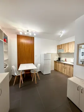 Modern kitchen with a dining area and wooden elements. - image 2
