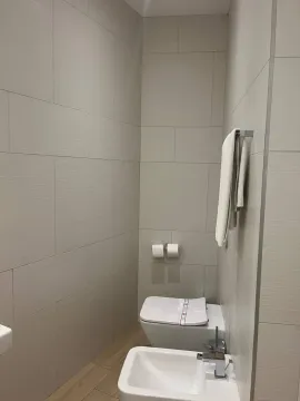 Modernly equipped bathroom with white sanitary ware and beige wall tiles. - image 3
