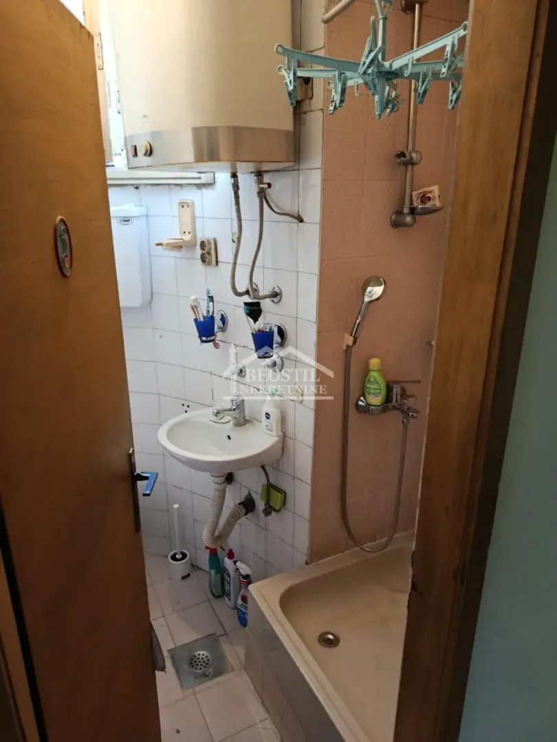 Manje kupatilo sa umivaonikom, tuš kadom i bojlerom.