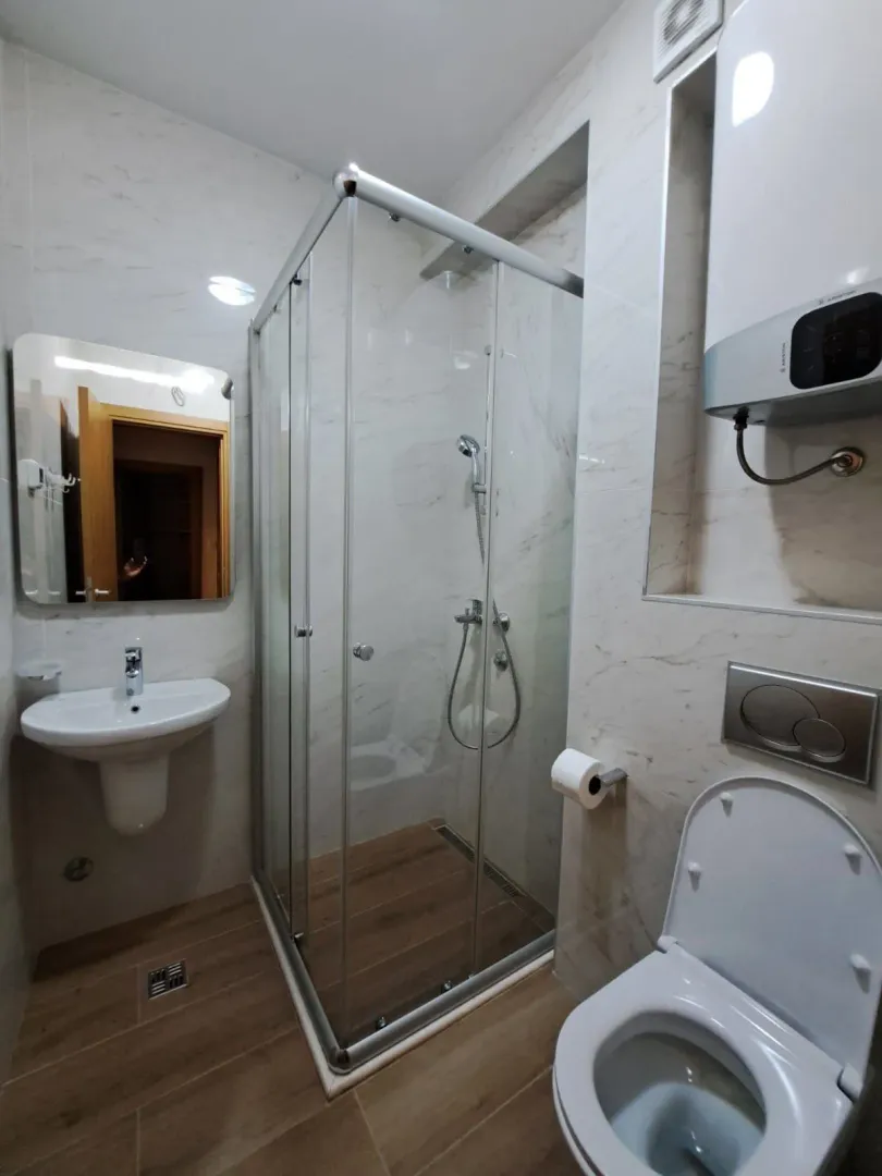 Moderno opremljeno kupatilo sa tuš kabinom, umivaonikom i wc šoljom.