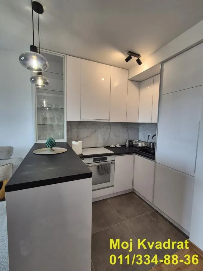 Modern kitchen with white cabinets and a breakfast bar.