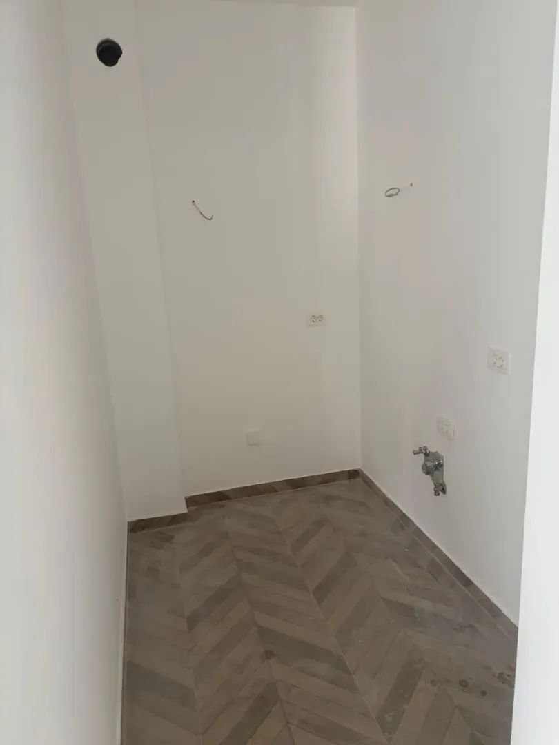 Manja prostorija sa priključcima za kuhinju i popločanim podom.