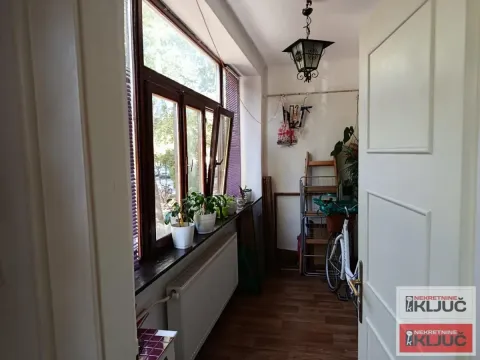 Zastakljena terasa sa prozorima, sobnim biljkama i biciklom. - image 5