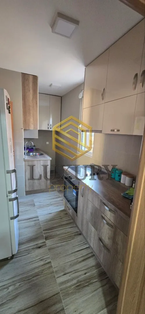 Modern kitchen with light cabinetry and built-in appliances.