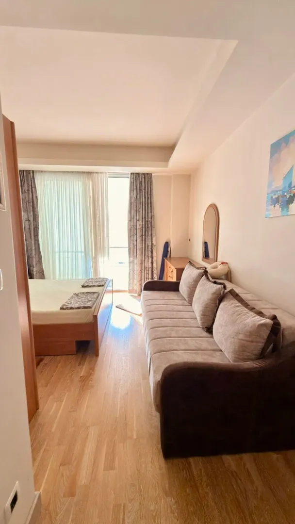 Bedroom with a double bed, a sofa and access to the terrace.