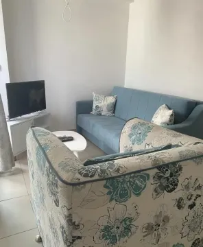 Dnevna soba sa plavom sofom, foteljom i televizorom. - image 4