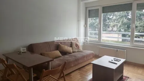 Dnevna soba sa garniturom za sedenje, trpezarijskim stolom i prozorima. - image 2