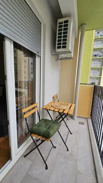 Manji namješten balkon sa drvenim stolom i stolicama. - image 9
