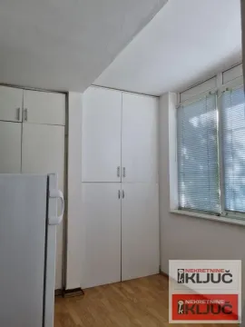 Beli kuhinjski elementi sa ugrađenim ormarima i frižiderom. - image 6