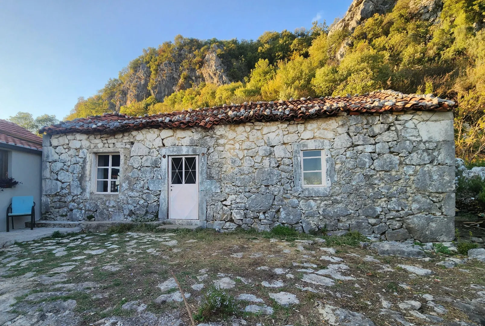 Eksterijer tradicionalne kamene kuće sa dvorištem.