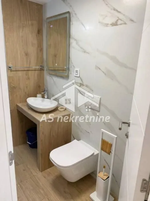 Moderno opremljeno kupatilo sa umivaonikom i wc šoljom.