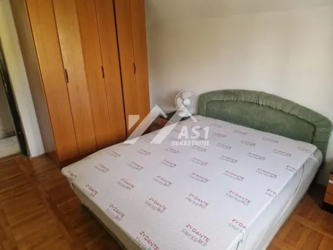 Bedroom with a bed and a large wooden wardrobe. - image 3