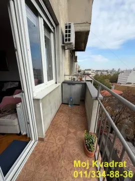 Small tiled balcony with a railing and city view. - image 10