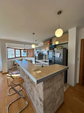 Kitchen with a breakfast bar and a dining area by the window. - image 2