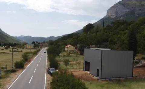 Aerial view of a modern building next to the road and mountain landscape. - image 5