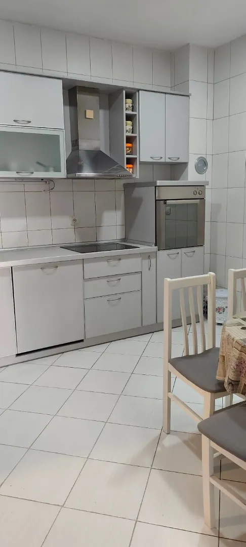 Bright kitchen with built-in appliances and a dining table.