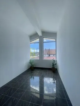 Empty bright room with dark floor tiles and large windows. - image 4