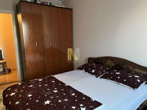 Spavaća soba sa bračnim krevetom i velikim drvenim ormarom. - image 11
