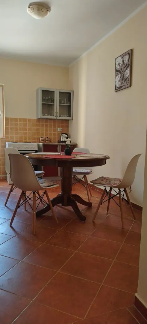 Dining area with a table and chairs and a part of the kitchen.