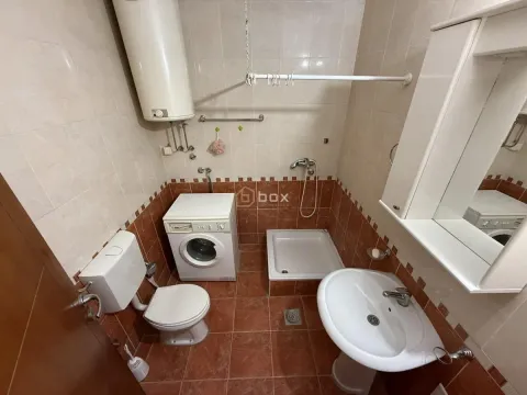 Smaller bathroom with a shower cabin, washbasin, toilet, and washing machine. - image 7