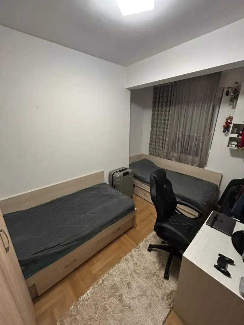 Dječja soba sa dva kreveta i radnim stolom.