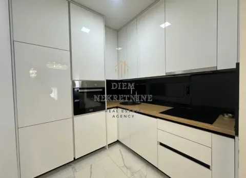 Modern white kitchen with built-in appliances and wooden countertop. - image 5