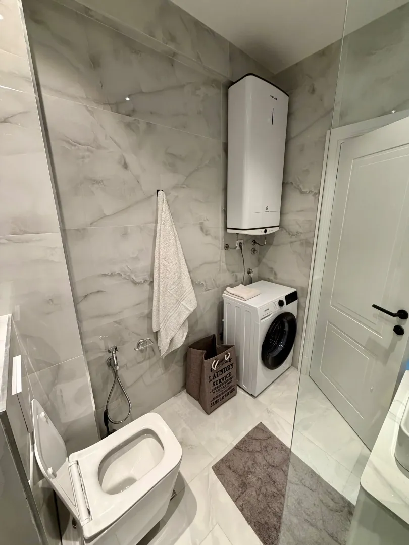 Modern bathroom equipped with a washing machine and water heater.