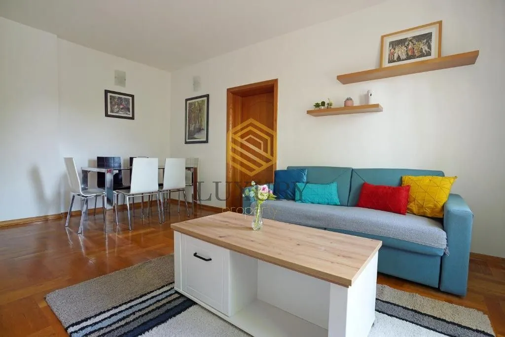 Living room with a sofa, coffee table, and dining area.