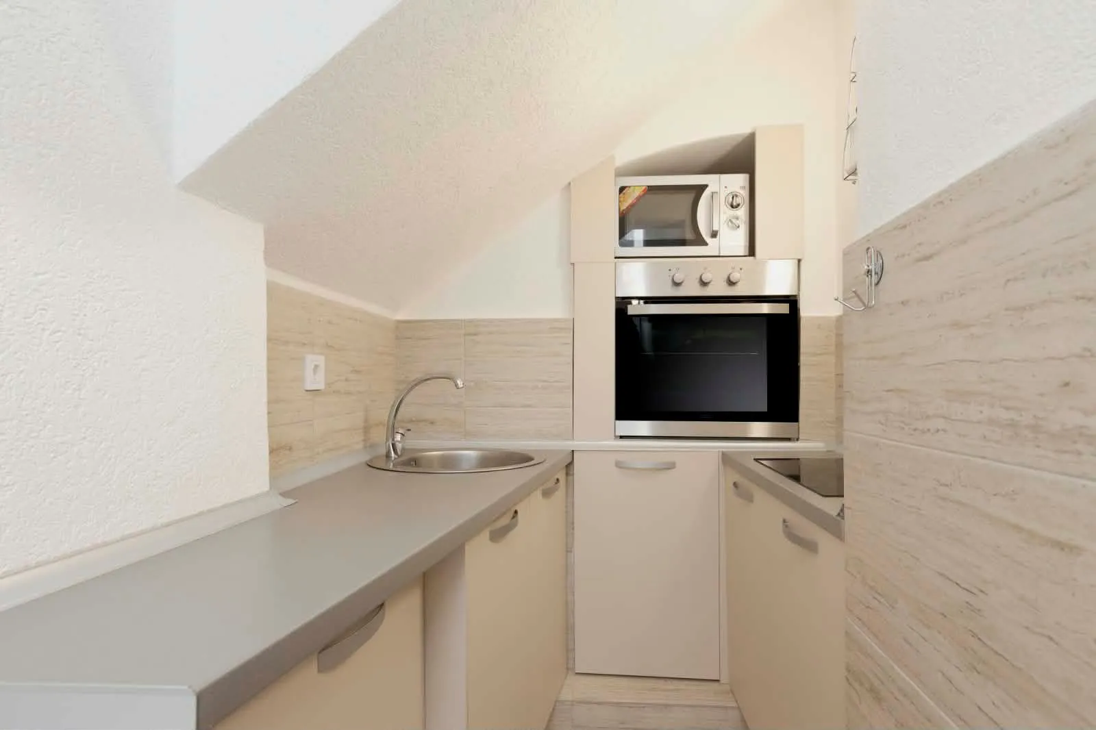 Small kitchen with built-in oven and microwave in the attic.