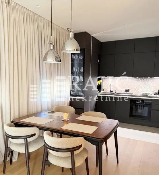 Modern kitchen with a dining area and dark cabinetry.