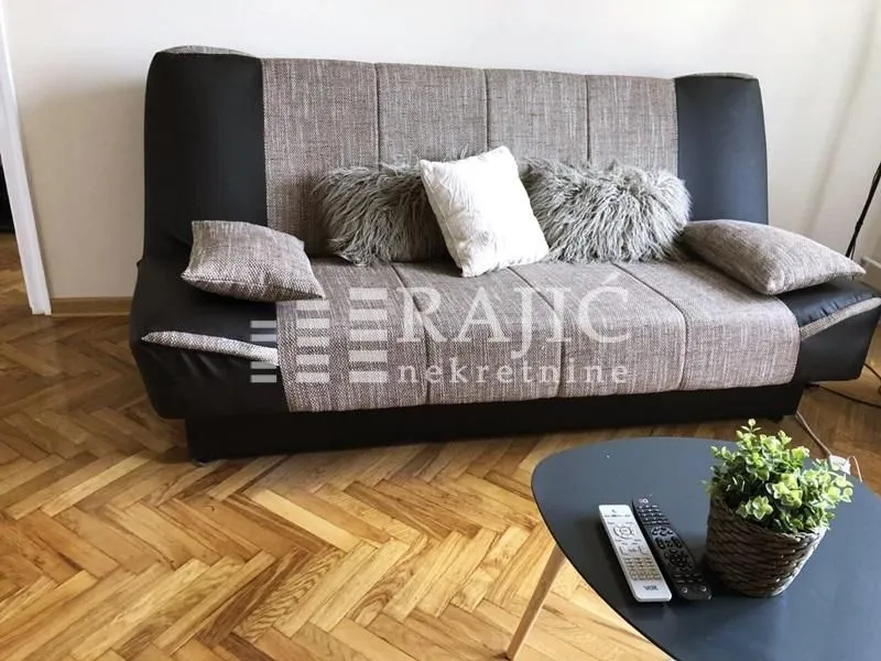 Living room with sofa and parquet flooring.