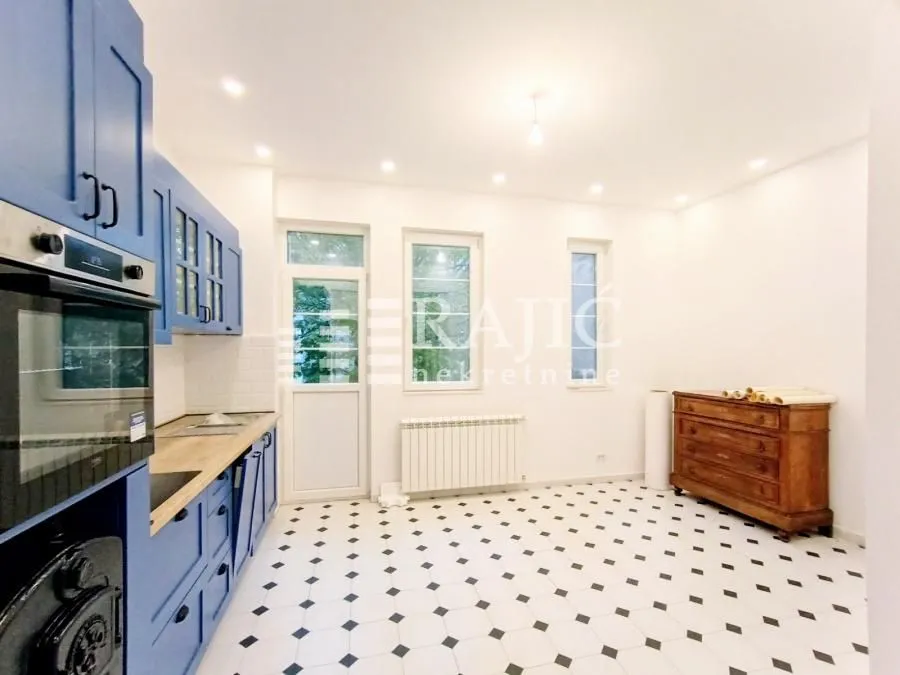 Kitchen with blue cabinets and black and white floor tiles.