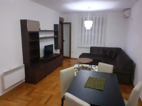 Living room with a corner sofa, TV stand, and a dining table. - image 5