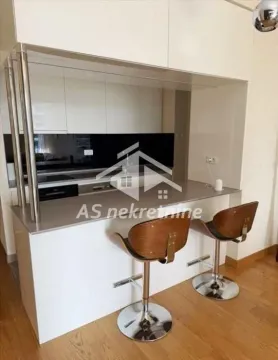 Moderna kuhinja sa šankom i drvenim barskim stolicama. - image 8