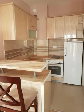 Small kitchen with wooden cabinetry, white refrigerator and a breakfast bar. - image 8