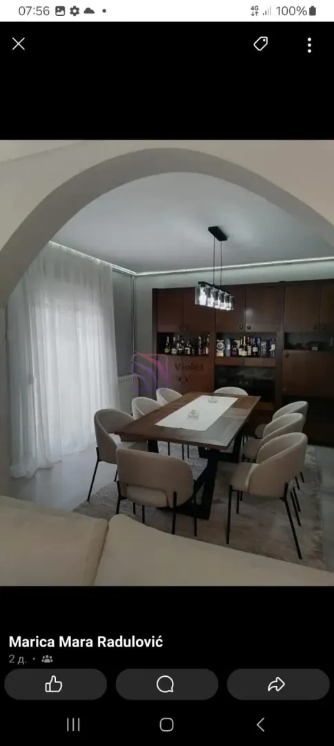 Dining room with a large table, chairs and a wooden display cabinet.