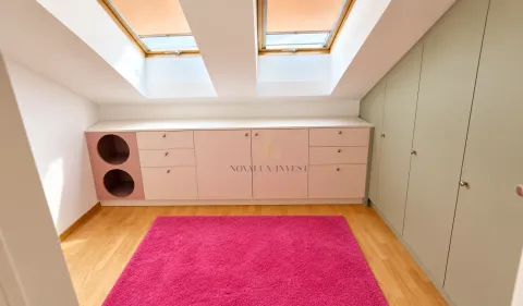 Attic room with built-in closets, low dressers, and skylight windows. - image 13