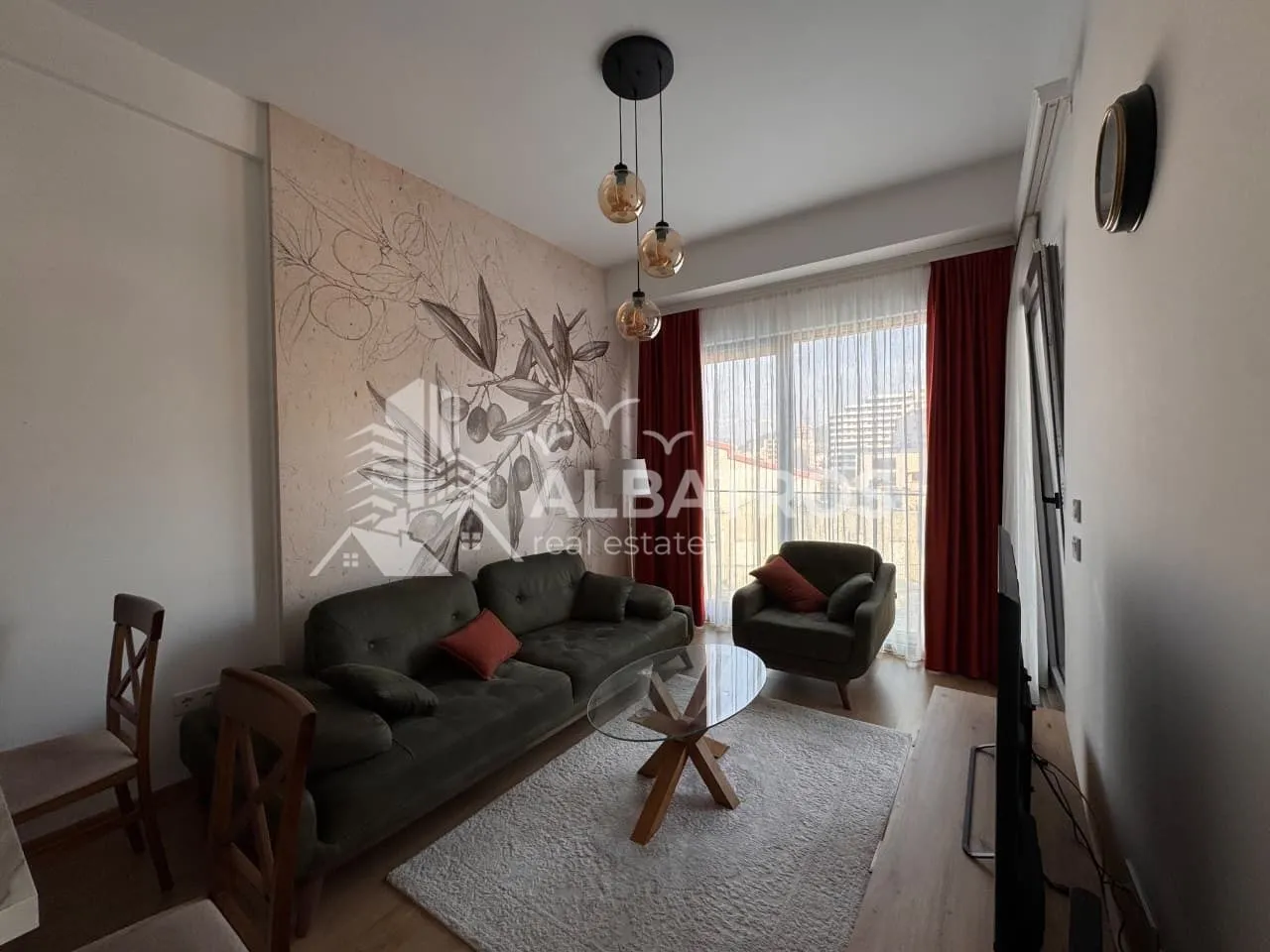 Living room with a sofa set, armchair, and access to the terrace.