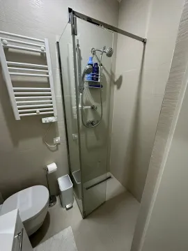 Kupatilo opremljeno tuš kabinom, WC šoljom i radijatorom za peškire. - image 12