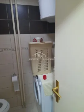 View of the bathroom with a washing machine and a laundry basket. - image 10