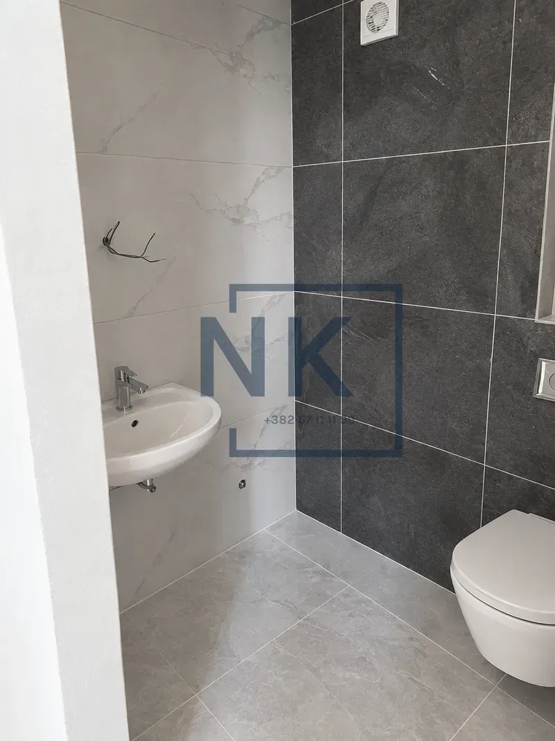 Savremeno opremljeno kupatilo sa umivaonikom i WC šoljom.