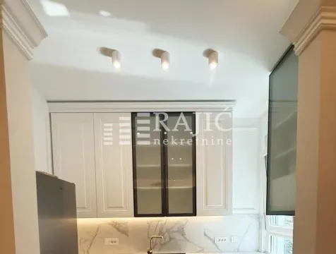 View of a modernly equipped kitchen with white elements. - image 9