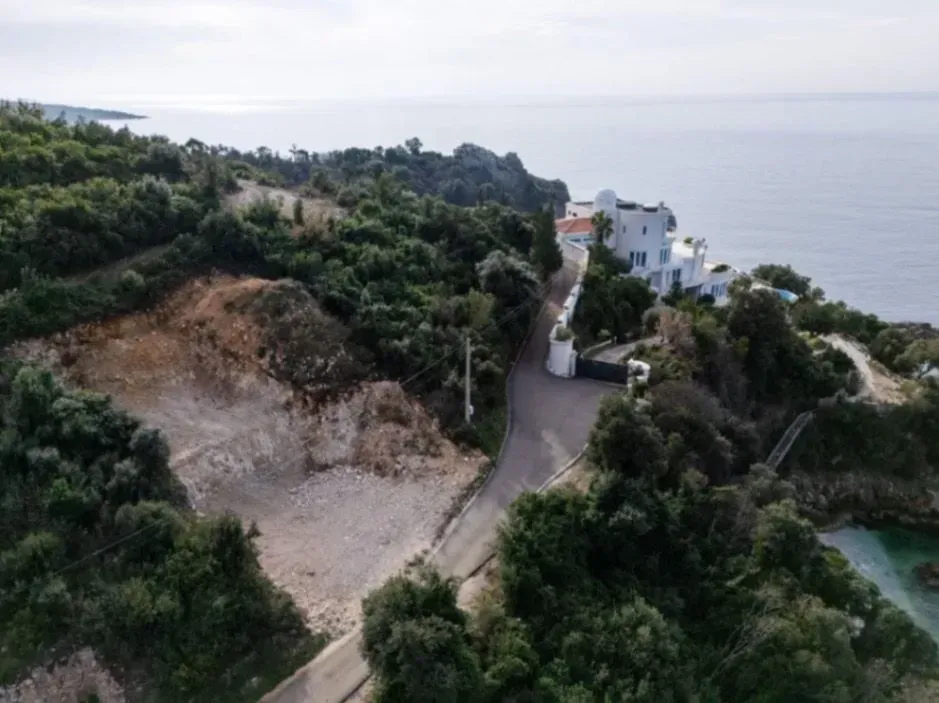 Pogled iz vazduha na imanje sa vilom pored mora i prilaznim putem.