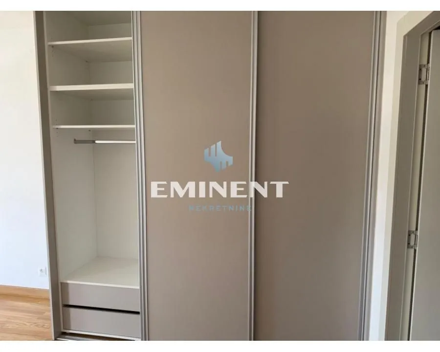 Built-in wardrobe with sliding doors and open shelves in the bedroom.