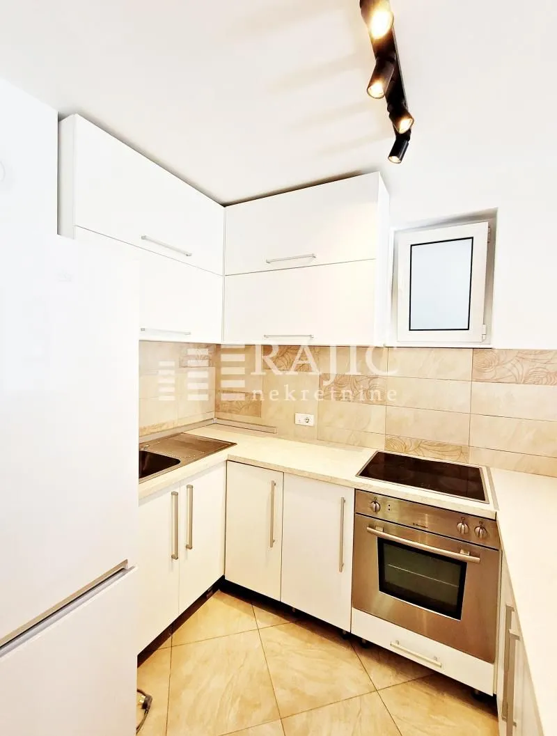 Smaller white kitchen with built-in appliances.