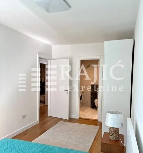 View of the bedroom with a bed and a doorway leading to the bathroom.
